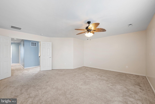 empty room featuring visible vents, light carpet, and baseboards