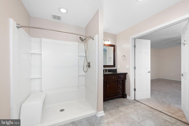 bathroom featuring vanity, walk in shower, and visible vents