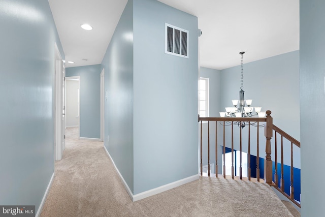 hall featuring baseboards, visible vents, carpet floors, a chandelier, and recessed lighting