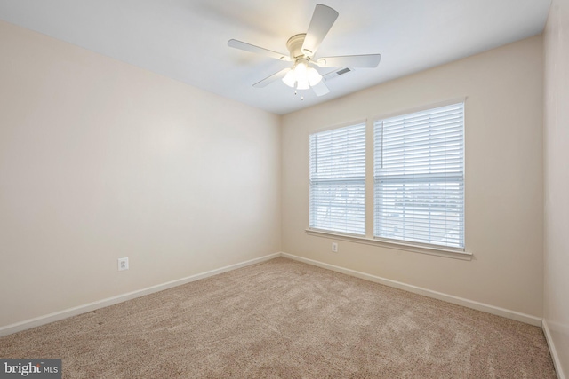 spare room featuring a ceiling fan, baseboards, visible vents, and carpet flooring