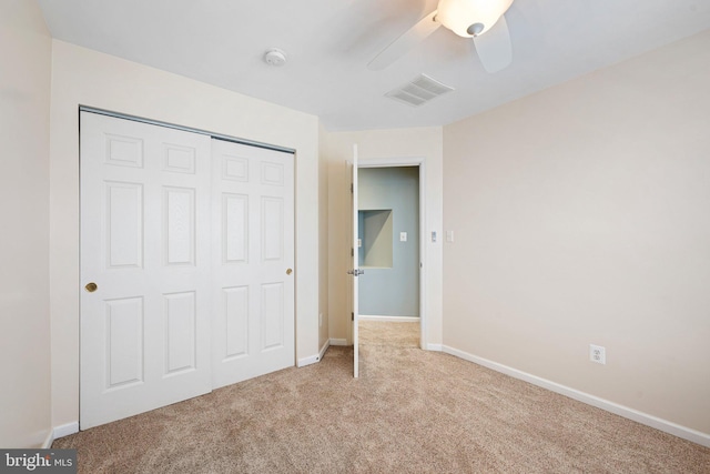 unfurnished bedroom with a closet, carpet flooring, visible vents, and baseboards