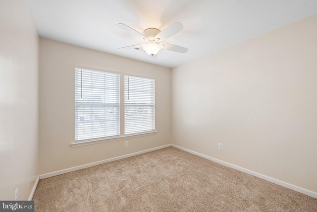 carpeted empty room featuring ceiling fan and baseboards