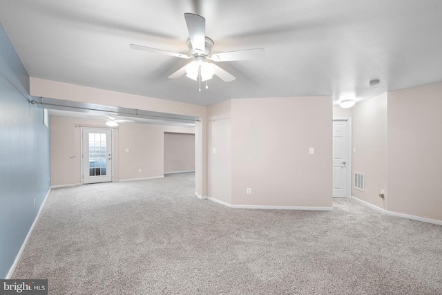 carpeted spare room with baseboards, visible vents, and a ceiling fan