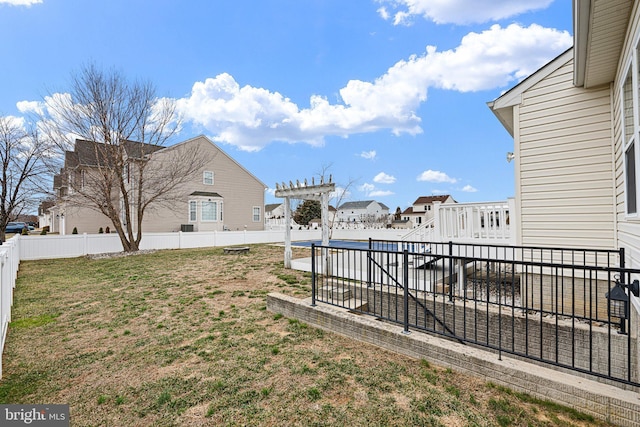 view of yard featuring a residential view, a fenced backyard, and a pergola