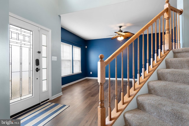 foyer with a ceiling fan, stairway, baseboards, and wood finished floors