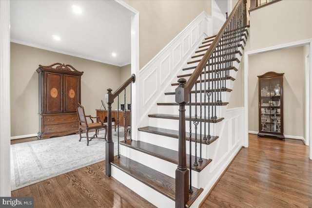 stairway featuring ornamental molding, recessed lighting, wood finished floors, and baseboards