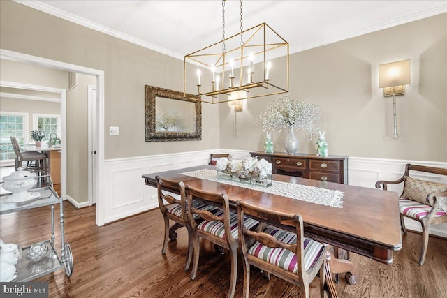 dining space featuring ornamental molding, wood finished floors, and wainscoting