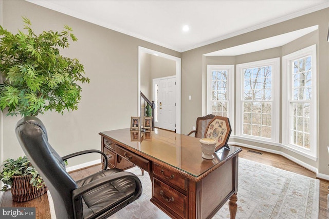 office area with ornamental molding, plenty of natural light, visible vents, and baseboards