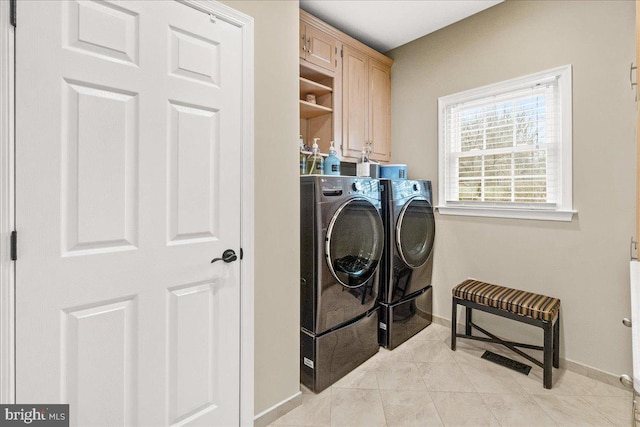 washroom featuring cabinet space, light tile patterned floors, baseboards, and independent washer and dryer