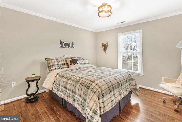 bedroom featuring crown molding, wood finished floors, and baseboards