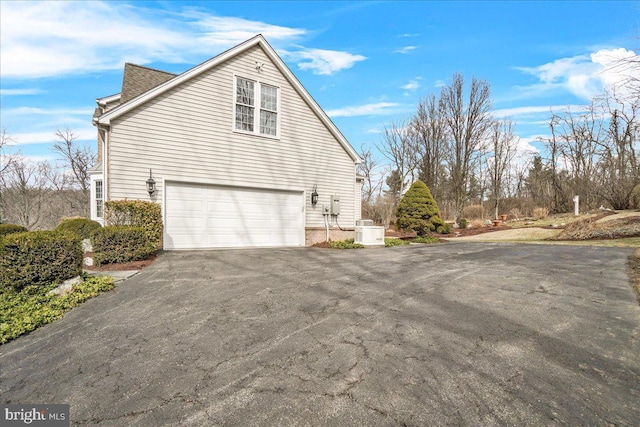 view of home's exterior with a garage and driveway