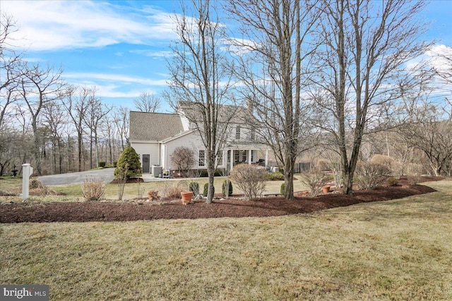 view of front of property featuring a front lawn and cooling unit