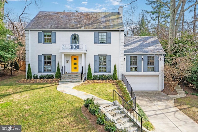 view of front of property with a front yard, a chimney, concrete driveway, a garage, and brick siding