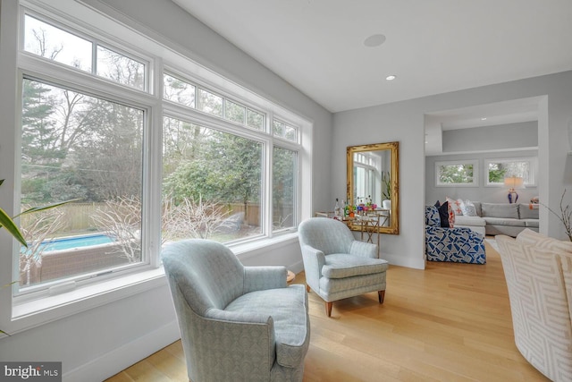 living area featuring recessed lighting, baseboards, and light wood-type flooring