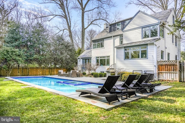 back of property featuring a lawn, an outdoor hangout area, a chimney, a fenced backyard, and a patio area