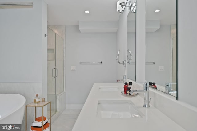 full bathroom featuring double vanity, a freestanding tub, a shower stall, and a sink