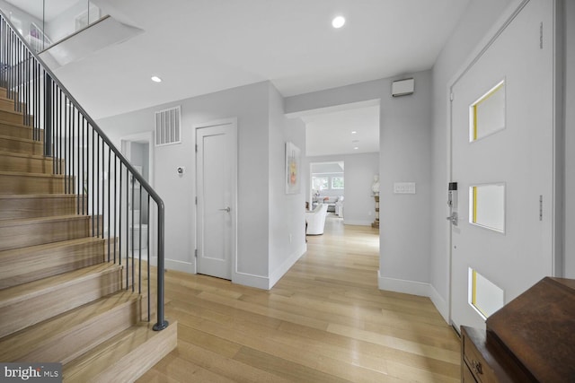 foyer with visible vents, baseboards, stairway, light wood-type flooring, and recessed lighting