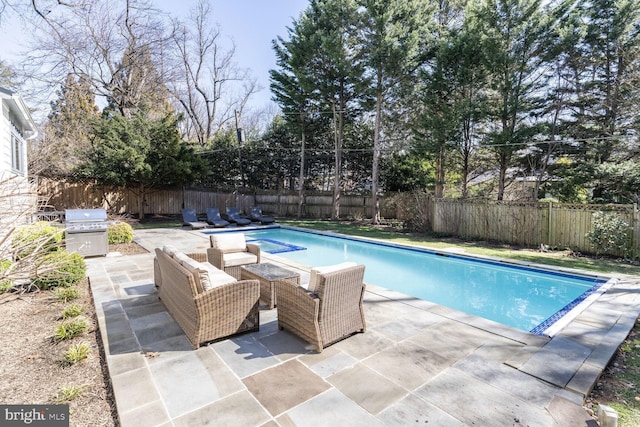 view of pool featuring a fenced backyard, grilling area, outdoor lounge area, a fenced in pool, and a patio area