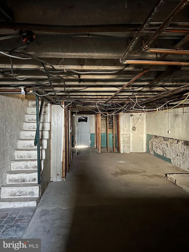 unfinished basement featuring stairs