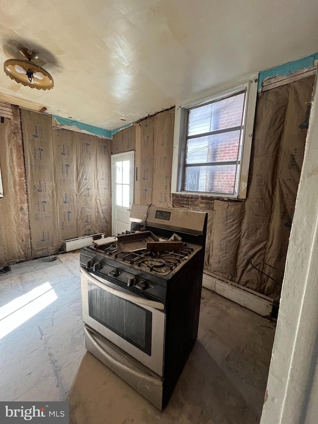 kitchen featuring a baseboard heating unit and stainless steel range with gas stovetop