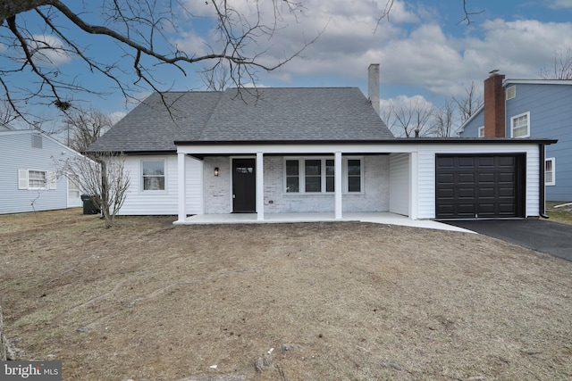 view of front of property with driveway, a garage, roof with shingles, a porch, and brick siding