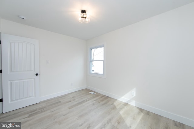 spare room featuring visible vents, wood finished floors, and baseboards
