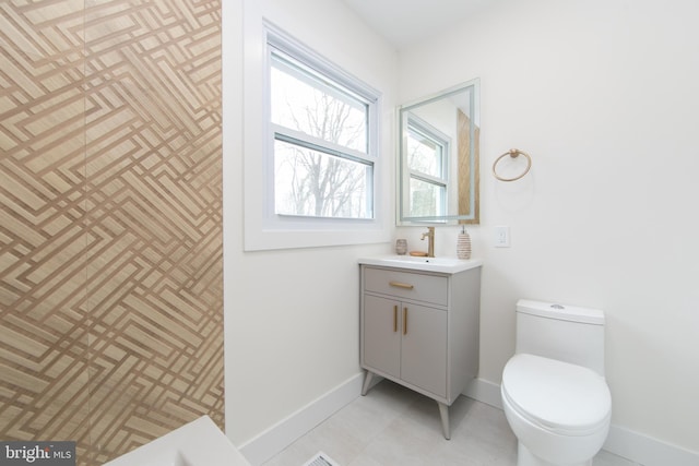 bathroom with baseboards, toilet, and vanity