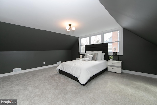 carpeted bedroom with lofted ceiling, baseboards, and visible vents