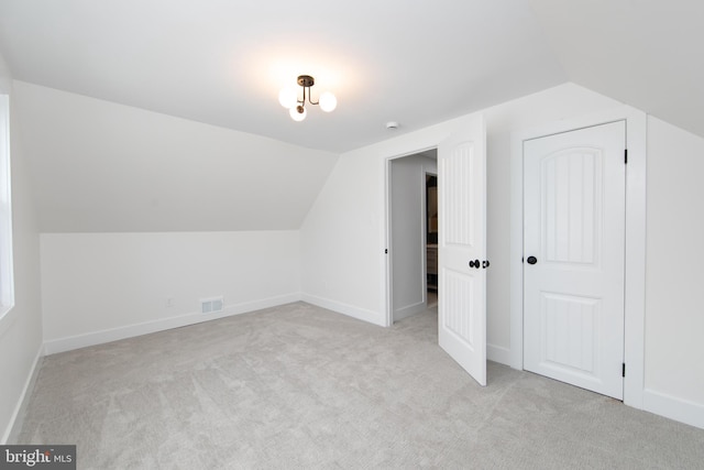 bonus room featuring visible vents, light carpet, baseboards, and vaulted ceiling