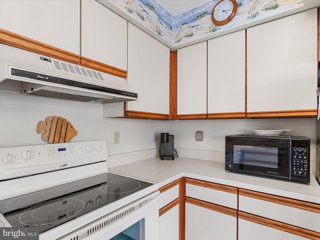 kitchen featuring under cabinet range hood, white cabinetry, black microwave, and white electric range