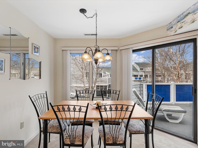 dining room with baseboards, visible vents, carpet floors, and an inviting chandelier