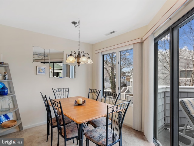 dining space with baseboards, visible vents, light carpet, and an inviting chandelier