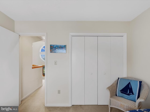 living area with baseboards and light colored carpet