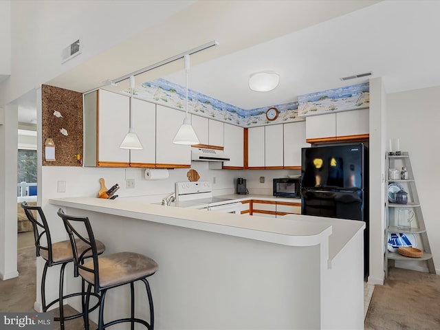 kitchen with under cabinet range hood, visible vents, a peninsula, and black appliances