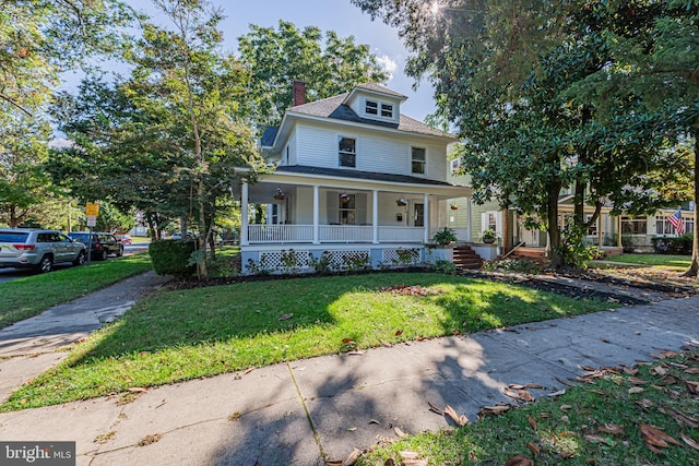 view of front of home featuring a chimney, a front lawn, and a porch