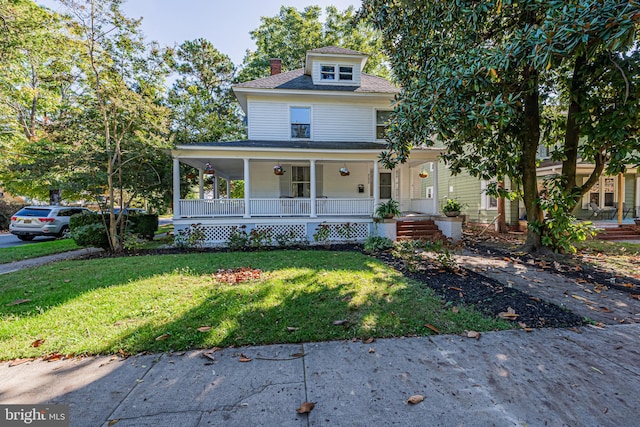 view of front of home featuring covered porch, a chimney, and a front lawn