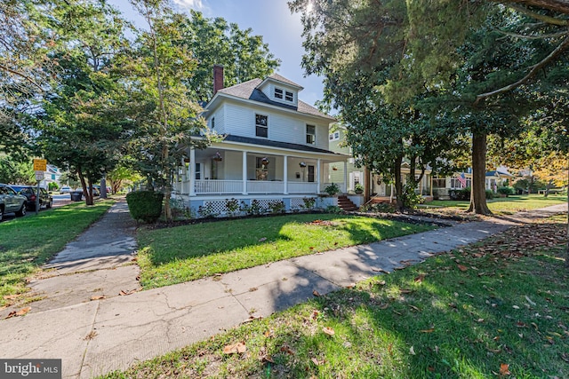 view of front of house featuring covered porch, a front lawn, and a chimney