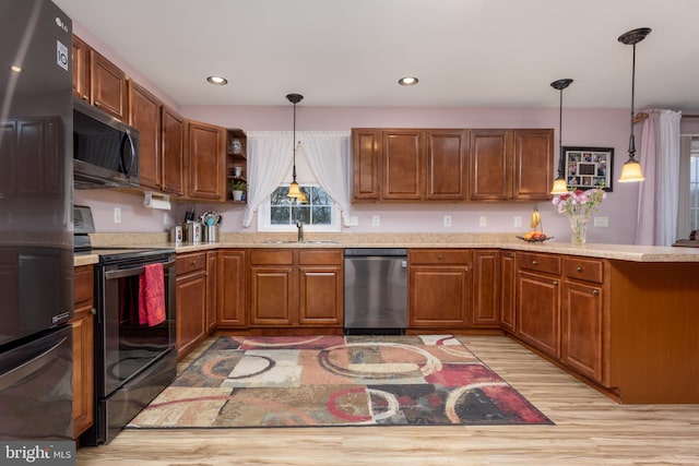 kitchen with hanging light fixtures, appliances with stainless steel finishes, a sink, and light countertops