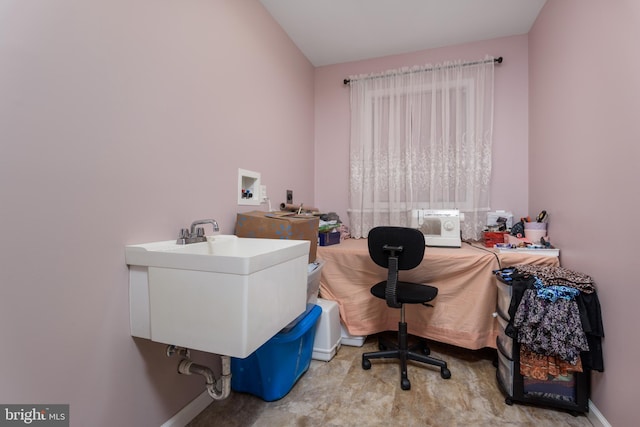 office space with a sink and baseboards