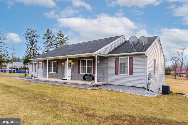 view of front of property featuring central AC, a front lawn, a porch, and a shingled roof