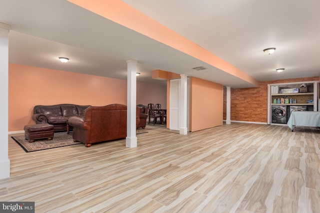 living room featuring separate washer and dryer, wood finished floors, visible vents, and baseboards