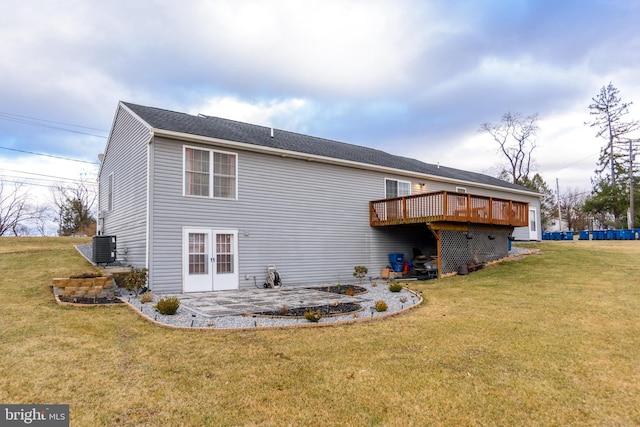 rear view of property featuring french doors, a lawn, a wooden deck, and central AC unit