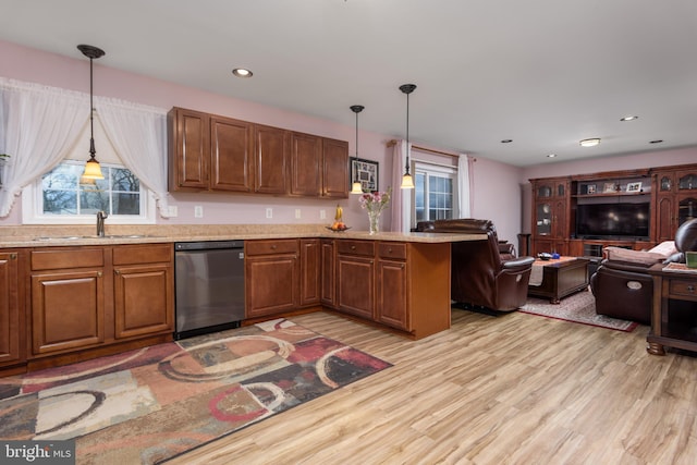 kitchen with light wood-style flooring, open floor plan, a sink, dishwasher, and a peninsula