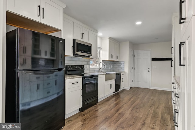 kitchen with black appliances, dark wood-style floors, white cabinets, and backsplash