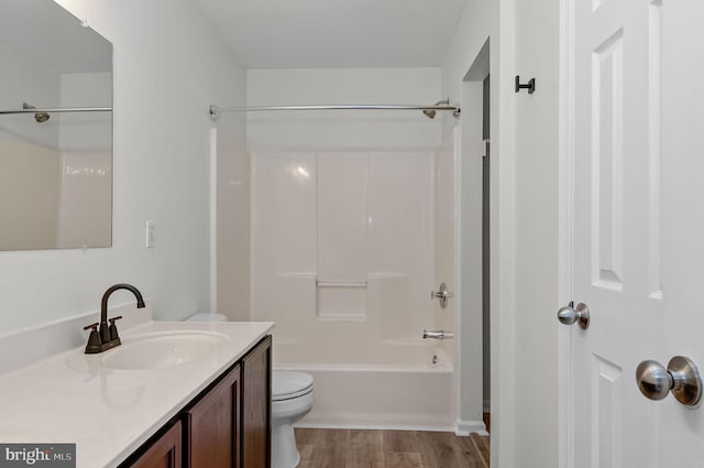 full bath featuring toilet, shower / tub combination, wood finished floors, and vanity