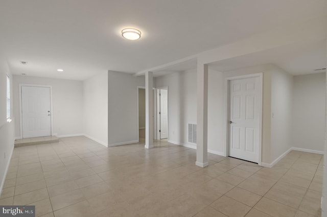 empty room with light tile patterned floors, baseboards, and visible vents