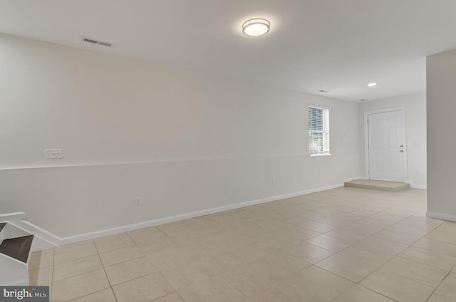 empty room with light tile patterned floors, baseboards, and visible vents