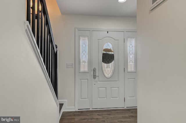 entryway with baseboards and dark wood-type flooring