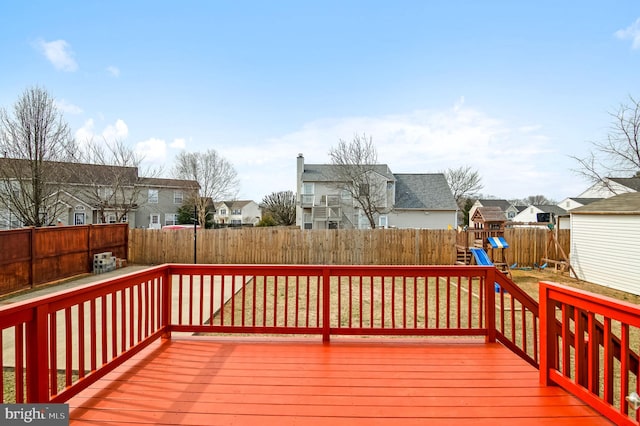 wooden terrace with a playground, a fenced backyard, and a residential view