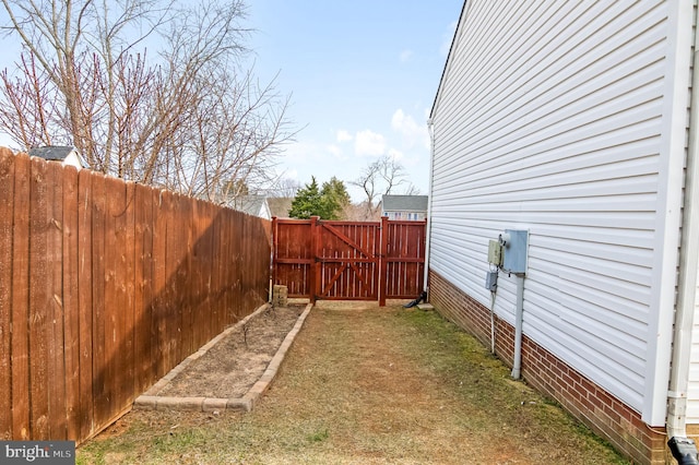 view of yard featuring a gate and a fenced backyard